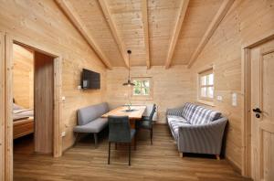 um quarto com uma mesa e cadeiras e um sofá em Knaus Campingpark Lackenhäuser em Neureichenau