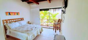 a bedroom with a bed and a large window at Palo Santo Beach club in Bocapán