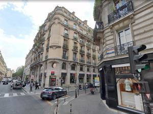 een drukke stadsstraat met een groot gebouw bij Dreamyflat - Ste Croix in Parijs
