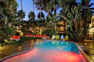 una piscina en un complejo con sillas y palmeras en Ocean Palms Beach Resort, en Carlsbad