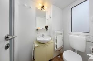 a bathroom with a sink and a toilet and a mirror at KNAUS Campingpark Bad Dürkheim in Bad Dürkheim +42 photos
