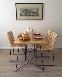 una mesa de madera con 2 sillas y un bol de fruta en Moderno apartamento en excelente ubicación en Buenos Aires