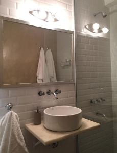 een witte badkamer met een wastafel en een spiegel bij Moderno apartamento en excelente ubicación in Buenos Aires