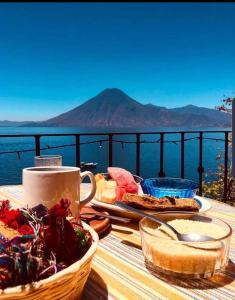 una mesa con comida y vistas al agua en The Paradise of Atitlán Suites apartamento completo, en Panajachel