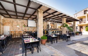 un patio esterno con tavoli e sedie in un ristorante di Villas Duc - Rhodes a Ialyssos
