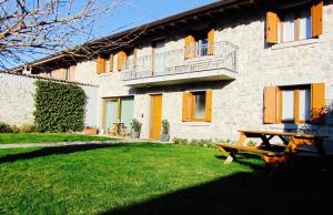 a house with a picnic table in front of it at Alc&cE' alloggio agrituristico in Povoletto