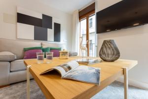 een woonkamer met een houten tafel met een boek erop bij Genteel Home Cabildo in Sevilla