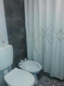 uma casa de banho com um WC branco e um lavatório. em Departamento A&F alquiler temporario em San Fernando del Valle de Catamarca