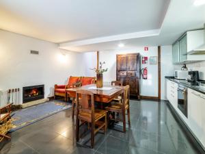 a kitchen with a table and chairs and a fireplace at Casa da Mencha in Vinhais