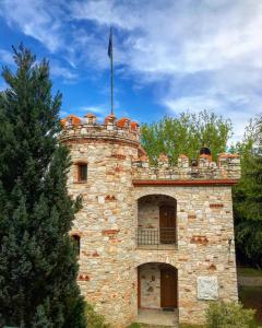 un edificio de piedra con una bandera encima en Hotel Nemesis en Stavroupoli