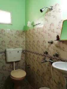a bathroom with a toilet and a sink at Madhukunda Homestay in Butwāl