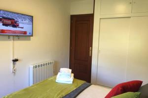 a room with a bed and a tv on the wall at PISO A 400 METROS DE LA CATEDRAL in Santiago de Compostela
