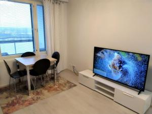 sala de estar con mesa de comedor y TV de pantalla plana en Pro Apartments 2 en Vaasa