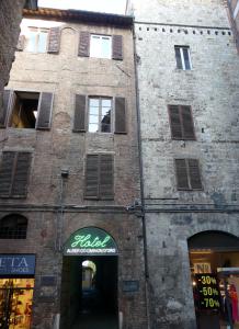 un viejo edificio de ladrillo con un cartel. en Albergo Cannon d'Oro, en Siena