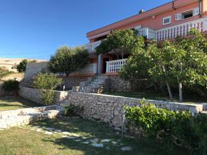 a house with a stone wall and trees at Holiday Home Panorama in Zubovići
