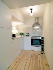 een keuken met witte apparatuur en een houten vloer bij FLH Porto Modern Flat in Porto