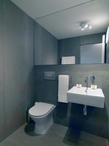 La salle de bains est pourvue de toilettes blanches et d'un lavabo. dans l'établissement FLH Porto Modern Flat, à Porto