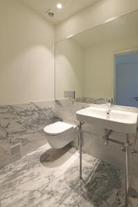 a bathroom with a sink and a toilet and a mirror at FLH Sá da Bandeira Luxury Apartment in Porto