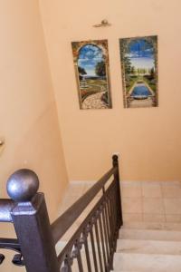 a staircase with three pictures on the wall and a stair case at Kefalos Villas in Razáta