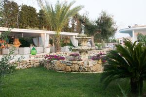 a garden with a fountain in front of a house at Residence Bellaria in Giurdignano