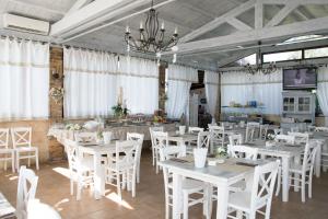 a dining room with white tables and white chairs at Residence Bellaria in Giurdignano