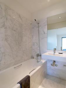 biała łazienka z wanną i umywalką w obiekcie FLH - Porto Charming Flat w mieście Matosinhos