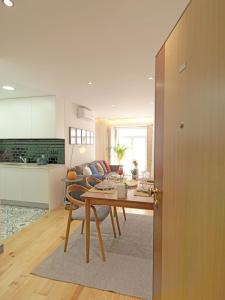 uma cozinha e sala de estar com uma mesa e um sofá em FLH Porto Modern Apartment em Porto