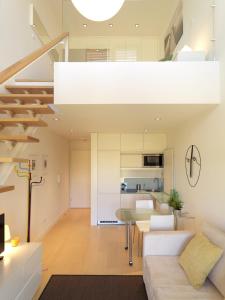 an open living room and kitchen with a spiral staircase at FLH - Porto Charming Flat in Matosinhos