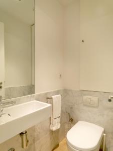 W łazience znajduje się umywalka, toaleta i lustro. w obiekcie FLH - Porto Charming Flat w mieście Matosinhos