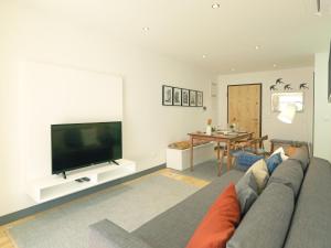 uma sala de estar com um sofá e uma televisão de ecrã plano em FLH Porto Modern Apartment no Porto