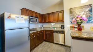 a kitchen with wooden cabinets and a refrigerator at Staybridge Suites Houston-NASA Clear Lake, an IHG Hotel in Webster