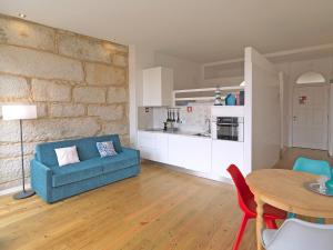 ein Wohnzimmer mit einem blauen Sofa und einem Tisch in der Unterkunft FLH Porto Cozy Studio in Porto