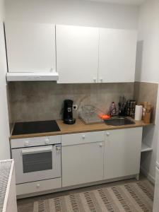 una cocina con armarios blancos y fregadero en your home !, en Amberes