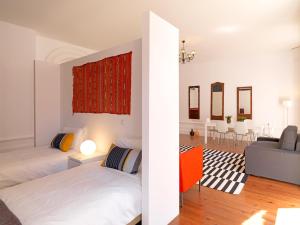 a bedroom with two beds and a living room at FLH Porto Charming Studio in Porto
