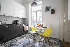 a kitchen with a table and yellow chairs at oompH Warsaw Central Elegant Apartment in Warsaw