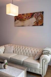 ein Wohnzimmer mit einer Couch und einem Gemälde an der Wand in der Unterkunft Rezidence Hadovitá in Prag