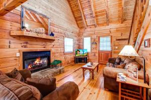 a living room with a fireplace in a log cabin at Country Hideaway in Sevierville