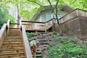 a house with a wooden staircase leading to a porch at Leprechaun Island in Gatlinburg