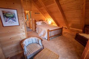 1 dormitorio con 1 cama y 1 silla en una cabaña en Premium Retreat on 450 Acres w/ Greenhouse, Meditation Room & Labyrinth, en Hillside