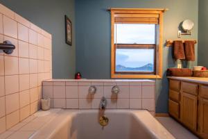 baño con bañera y ventana en Premium Retreat on 450 Acres w/ Greenhouse, Meditation Room & Labyrinth, en Hillside