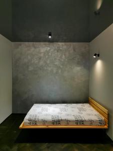 a bed in a room with a wall at Loft style apartments in the center in Sumy