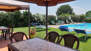patio ze stołami i krzesłami oraz basenem w obiekcie La Casa delle Rondini w mieście Lamporecchio +14 zdjęć