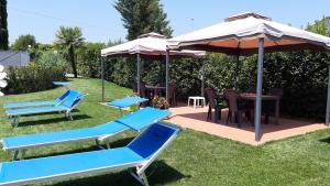 a patio with blue chairs and an umbrella at La Casa delle Rondini in Lamporecchio