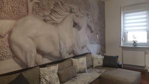 ein Wohnzimmer mit einem Sofa und einem großen Gemälde an der Wand in der Unterkunft Zucht- und Ausbildungsstall Rubly in Kleinbundenbach