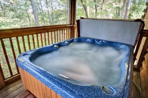 a bath tub sitting on a porch with a window at Afternoon Delight 1 Bedroom Cabin Rental between Gatlinburg and Pigeon Forge Great Couple getaway in Sevierville +2 photos