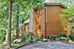 a log cabin in the woods with a driveway at Sticks And Stones in Sevierville