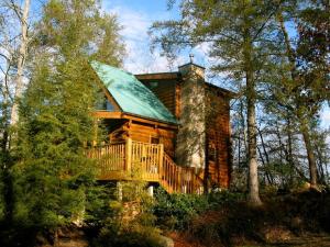 a log cabin with a balcony and a house at Sticks and Stones in Sevierville
