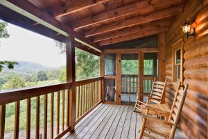 a porch of a cabin with two chairs on it at Sticks and Stones in Sevierville