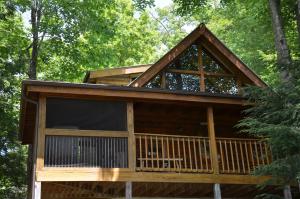 a cabin in the woods with a large window at Sticks and Stones in Sevierville +4 photos