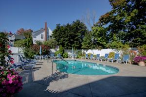 a swimming pool with chairs and a table at Terrace By The Sea in Ogunquit